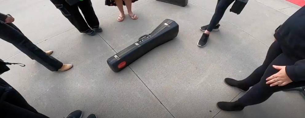 Instrument case set down on the sidewalk between performances