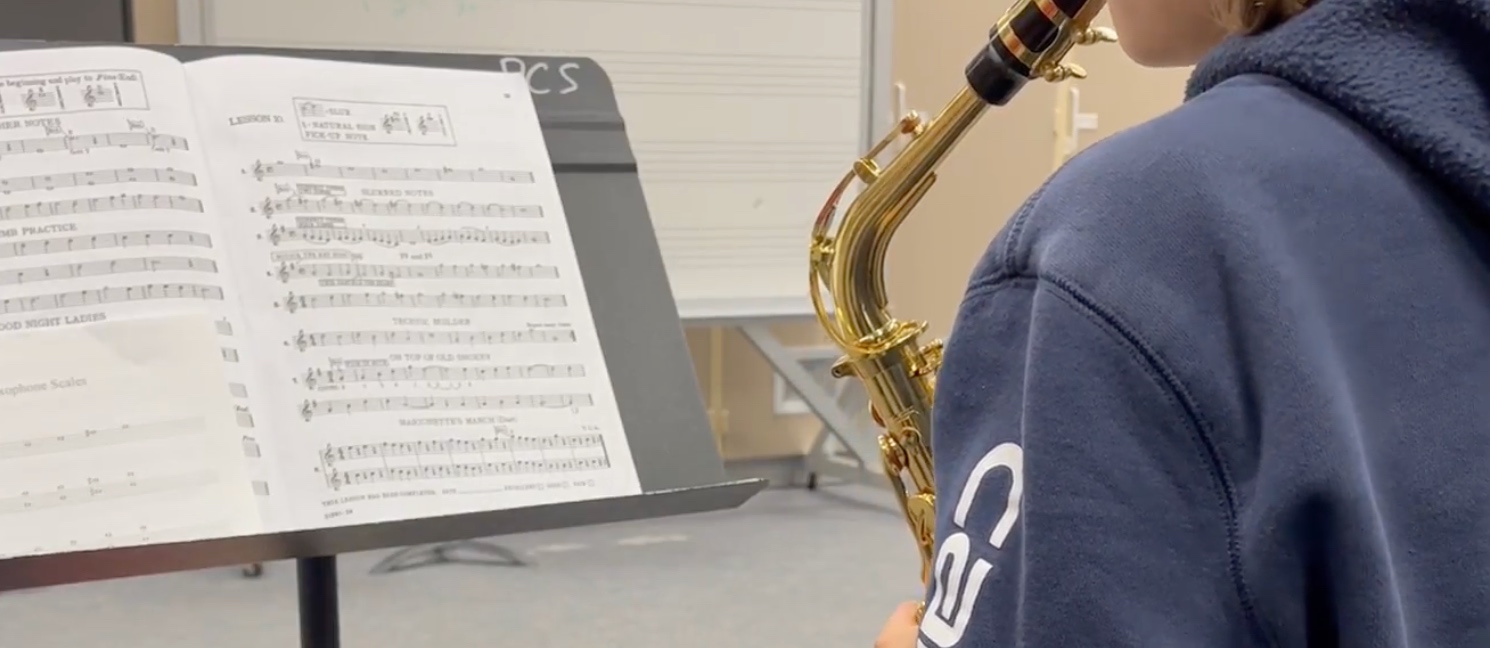 Alto-sax student reading from a Breeze Easy lesson book